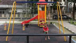 Seorang anak bermain ayunan di RPTRA Tiga Durian, Jakarta, Selasa (15/5). Pembangunan Taman Maju Bersama rencananya akan dimulai pada Mei 2018 dengan anggaran pembangunan sekitar Rp 27 miliar. (Liputan6.com/Immanuel Antonius)