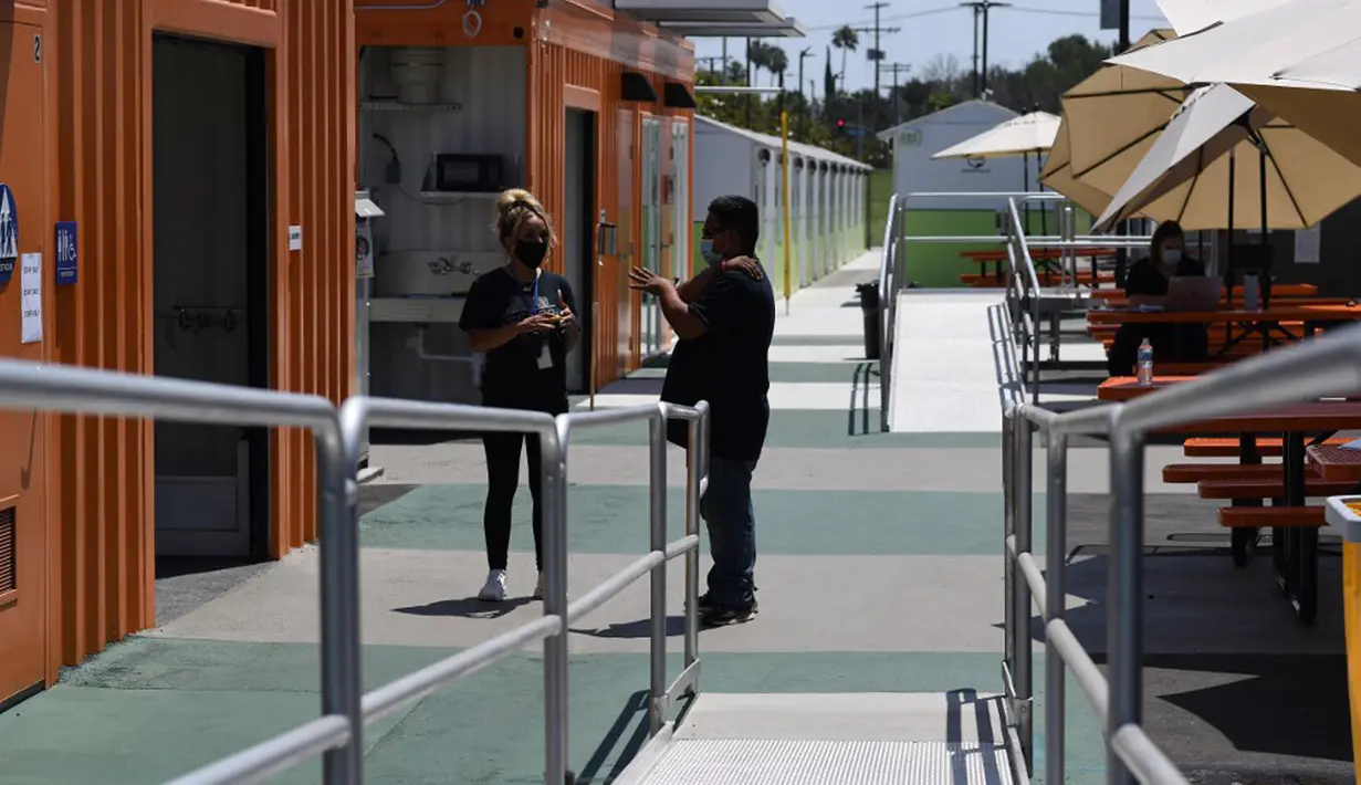 Anggota staf berbicara di area umum di Tarzana Tiny Home Village yang menawarkan perumahan sementara bagi para tunawisma di lingkungan Tarzana, Los Angeles, California, Amerika Serikat, 9 Juli 2021. (Robyn Beck/AFP)