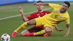 Penyerang Ukraina, Roman Yaremchuk, berebut bola dengan bek Swiss, Nico Elvedi, pada laga Nations League di Stadion Arena Lviv, Jumat (4/9/2020) dini hari WIB. Ukraina menang 2-1 atas Swiss. (AFP/Anatolii Stepanov)