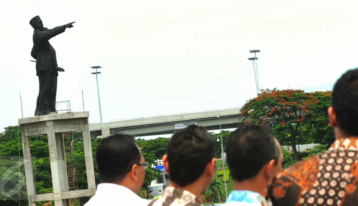 Warga saat melihat pengerjaan patung Soekarno-Hatta di kawasan bandara internasional Soekarno Hatta, Tangerang, Banten, (27/1/16). Pemindahan patung terkait rencana pembangunan Bandara Soetta. (Liputan6.com/Faisal R Syam)