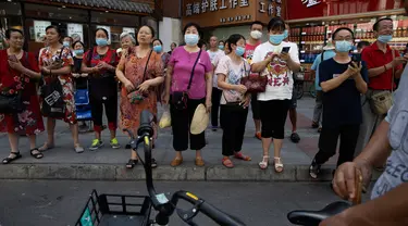 Orang-orang berkumpul ketika pihak berwenang China bersiap untuk memasuki Konsulat Amerika Serikat (AS) di Chengdu, Senin (27/7/2020). Bendera Amerika Serikat di Konsulat AS Chengdu diturunkan Senin (27/7), menandai ditutupnya kantor perwakilan Negeri Paman Sam di kota itu. (AP Photo/Ng Han Guan)