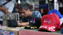 Topi dengan border logo PON XIX Jabar diperdagangkan di GOR Universitas Pendidikan Indonesia, Senin (19/9). Beberapa pedagang memanfaatkan moment PON XIX Jabar untuk menjual beragam pernak pernik. (Liputan6.com/Helmi Fithriansyah)