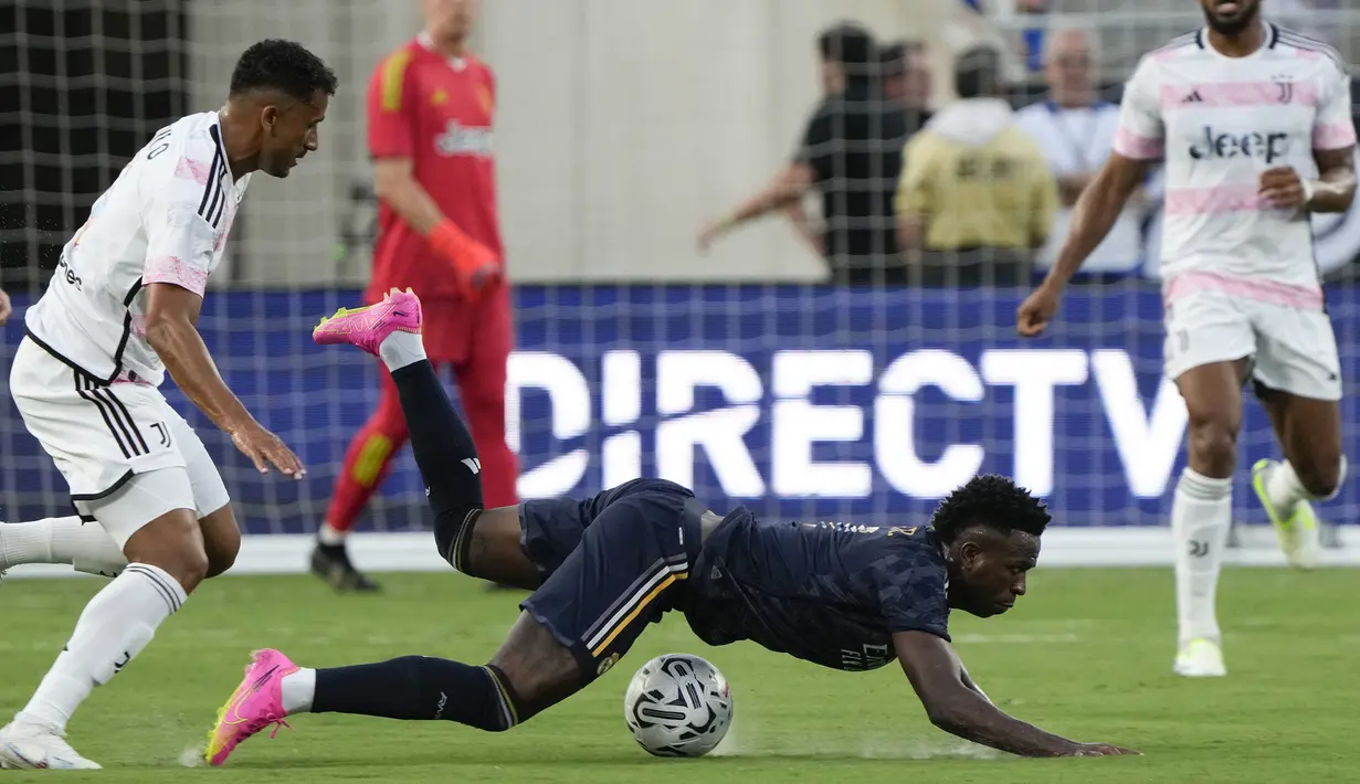 Pemain Real Madrid, Vinicius Jr (tenagah) terjatuh setelah berebut bola dengan pemain Juventus, Danilo pada laga uji coba pramusim di Camping World Stadium, Orlando, Florida, Amerika Serikat, Kamis (03/08/2023) WIB. (AP Photo/John Raoux)
