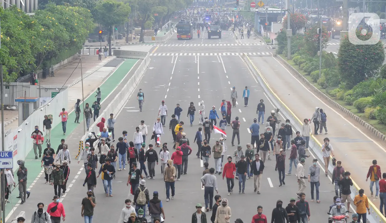 Petugas Brimob Polri menembakkan gas air mata untuk membubarkan massa usai terjadi lemparan batu di Jalan MH Thamrin, Jakarta, Selas (13/10/2020). Massa pengunjuk rasa yang menolak Omnibus Law akhirnya dibubarkan aparat. (merdeka.com/Arie Basuki)