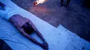 Seorang pria Hindu Nepal berguling di tepi sungai Hanumante saat festival Madhav Narayan di Bhaktapur, Nepal (31/1). Ritual ini untuk persembahan kepada Dewi Swasthani dan Dewa Siwa. (AP Photo / Niranjan Shrestha)