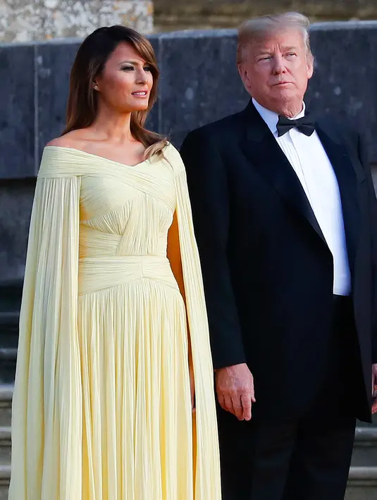 Presiden AS Donald Trump dan Melania Trump  menghadiri acara makan malam di Bleinheim Palace, Inggris, Kamis (12/7). Gaya Melania ini begitu cantik dan elegan bak Putri Disney di acara makan malam dengan PM Theresa May. (AP/Pablo Martinez Monsivais)