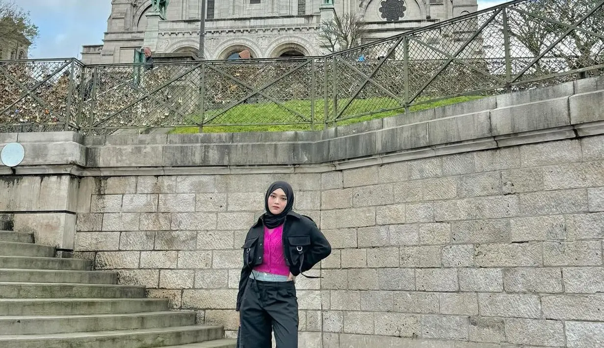 Potret chic Putri Delina pakai outfit hitam. Ia padukan atasan bernuansa keunguan, ditumpuknya dengan cropped jacket, celana panjang, dan hijab yang semuanya berwarna hitam. [Foto: Instagram/putridelinaa]