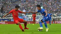 Ahmad Alfarizi coba melewati Asnawi Mangkualam pada uji coba Arema vs Timnas Indonesia U-22 di Stadion Kanjuruhan, Kabupaten Malang, Minggu (10/2/2019). (Bola.com/Iwan Setiawan)