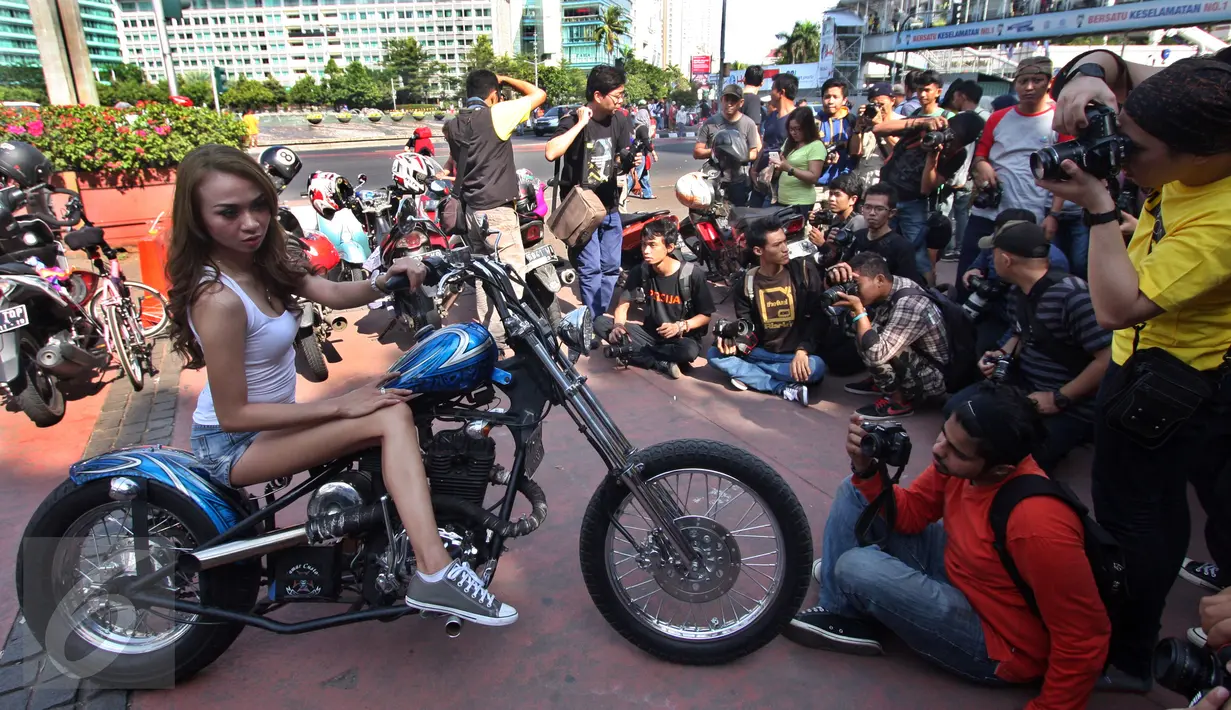 Seorang model berpose di atas motor gede di Jalan MH Thamrin, Jakarta, Minggu (19/7/2015). Momen Jakarta sepi akibat banyak yang mudik, dimanfaatkan fotografer untuk memotret model. (Liputan6.com/Johan Tallo)