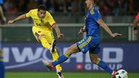 Gelandang Rumania, Nicolae Stanciu (kiri) melakukan tembakan ke arah gawang Ukraina (29/5/2016). Stanciu diprediksi bakal menjadi bintang muda yang menonjol pada Euro 2016.  (AFP/Marco Bertorello)
