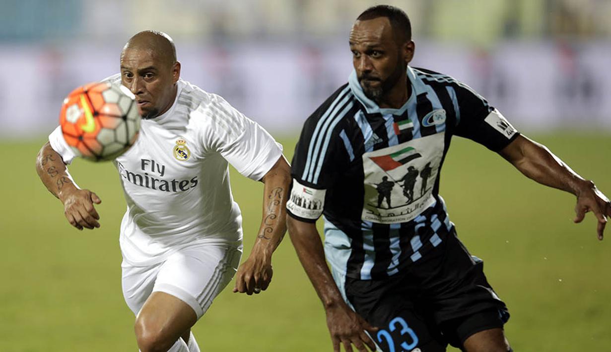 Legenda Real Madrid, Roberto Carlos, berusaha melewati pemain BaniYas FC pada laga persahabatan di Abu Dhabi, UEA, Jumat (5/12/2015). (EPA/Ali Haider)