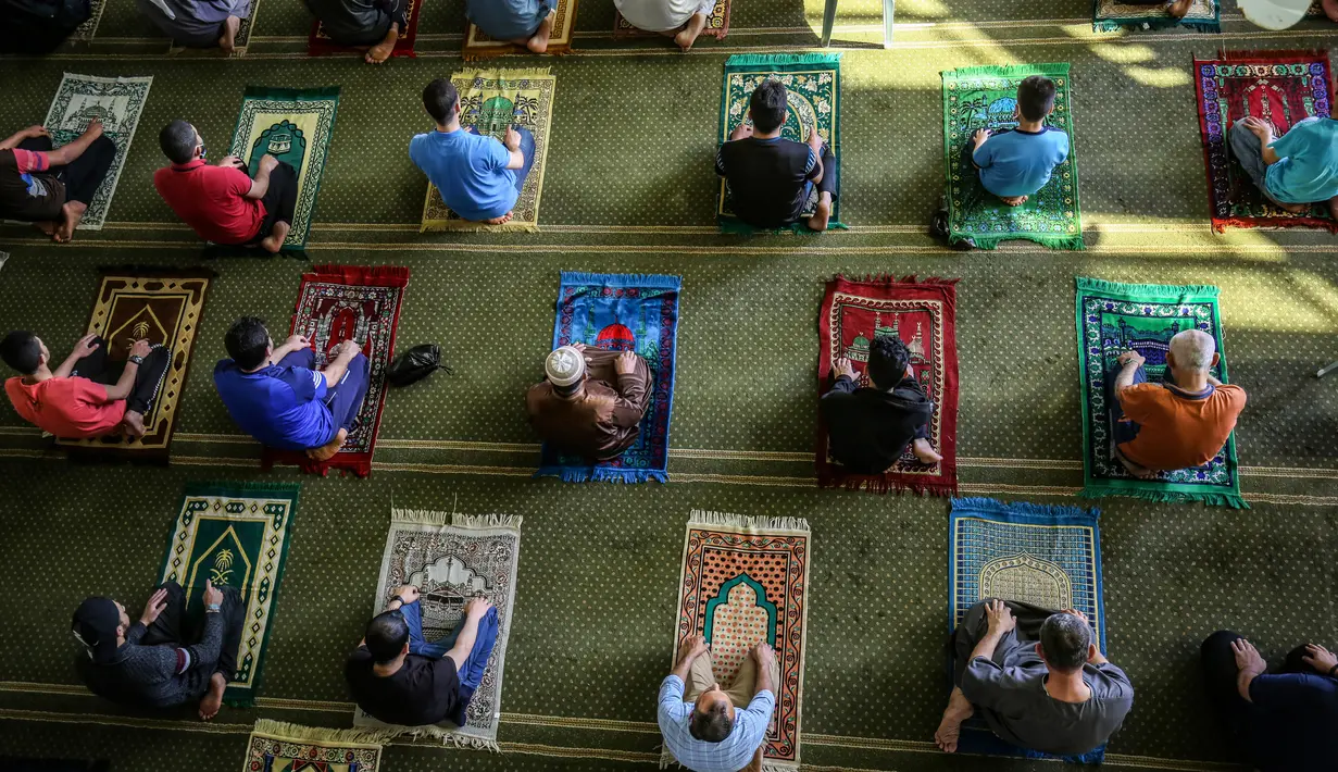 Orang-orang Palestina menjaga jarak ketika mereka ikut serta dalam salat zuhur di masjid Al-Abrar di Rafah, selatan Jalur Gaza, Rabu (3/6/2020). Masjid-masjid kembali dibuka bagi jemaah menyusul pelonggaran pembatasan Covid-19 di Jalur Gaza. (Photo by SAID KHATIB / AFP)