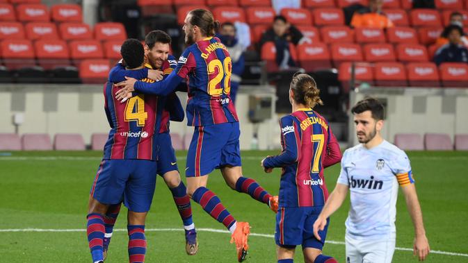 Para pemain Barcelona merayakan gol kedua yang dicetak bek Ronald Araujo (kiri) ke gawang Valencia dalam laga lanjutan Liga Spanyol 2020/21 di Camp Nou Stadium, Barcelona, Sabtu (19/12/2020). Barcelona bermain imbang 2-2 dengan Valencia. (AFP/Lluis Gene)