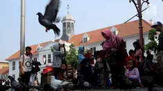 Wisatawan menikmati suasana kawasan Kota Tua, Jakarta, Selasa (20/11). Libur Maulid Nabi 2018 dimanfaatkan warga untuk berwisata di sejumlah lokasi, Salah satu yang ramai dikunjungi yakni Kota Tua. (Liputan6.com/Johan Tallo)