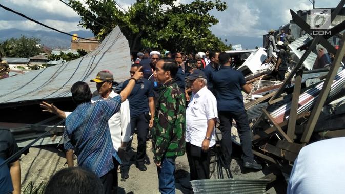 Presiden Joko Widodo (Jokowi) meninjau lokasi reruntuhan bangunan akibat gempa dan tsunami di Kota Palu, Sulawesi Tengah, Minggu (30/9). Jokowi tampak didampingi sejumlah menteri, termasuk Menteri PUPR, Basuki Hadimuljono. (Liputan6.com/Septian Deny)