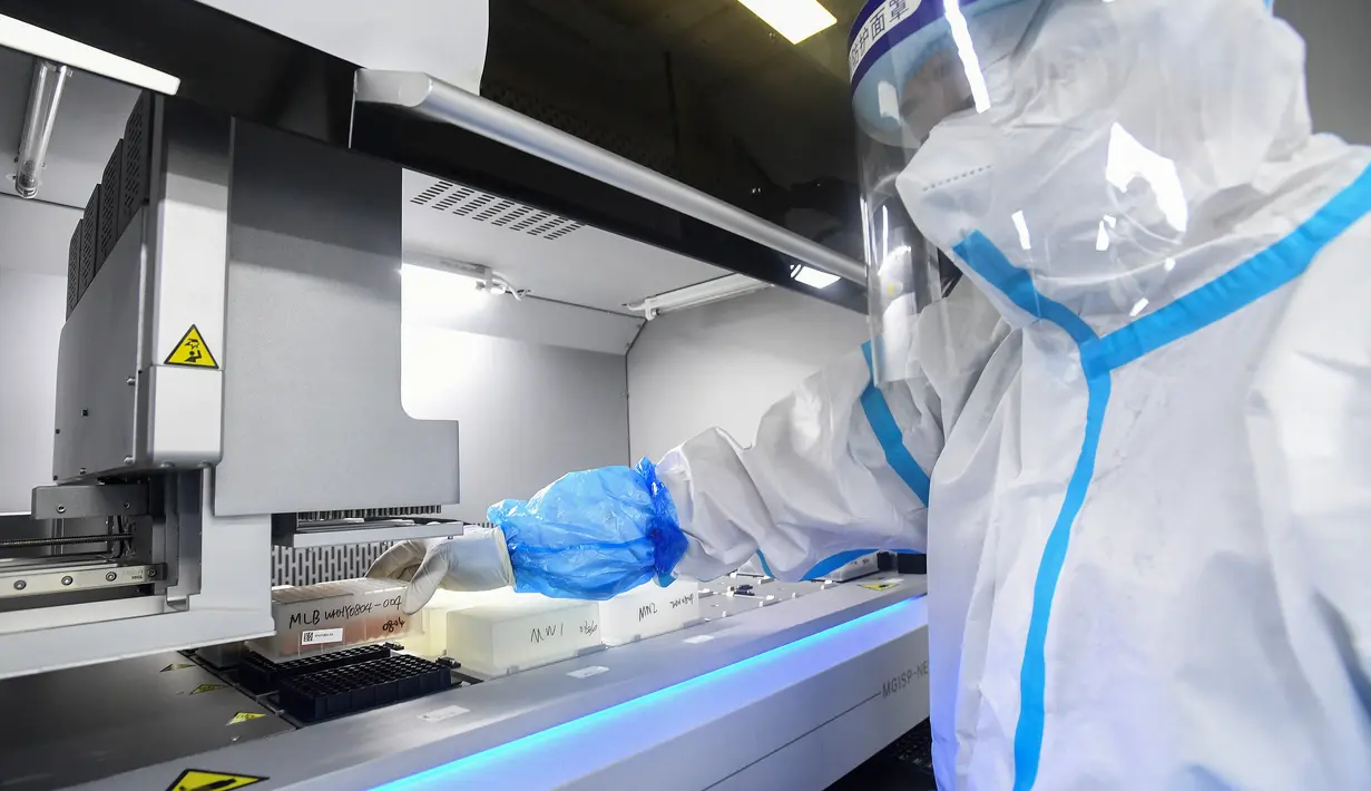 Seorang teknisi laboratorium yang mengenakan alat pelindung diri (APD) bekerja pada sampel yang akan diuji untuk virus corona Covid-19 di laboratorium Mata Api, fasilitas pengujian Covid-19, di Wuhan di provinsi Hubei tengah China (5/8/2021). (AFP/STR)