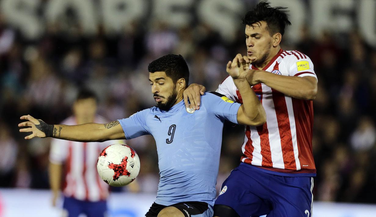 Striker Uruguay, Luis Suarez, berebut bola dengan bek Paraguay, Gustavo Gomez, pada laga kualifikasi piala dunia 2018 di Stadion Defensores del Chaco, Rabu (6/9/2017). Uruguay menang 2-1 atas Paraguay. (AP/Jorge Saenz)