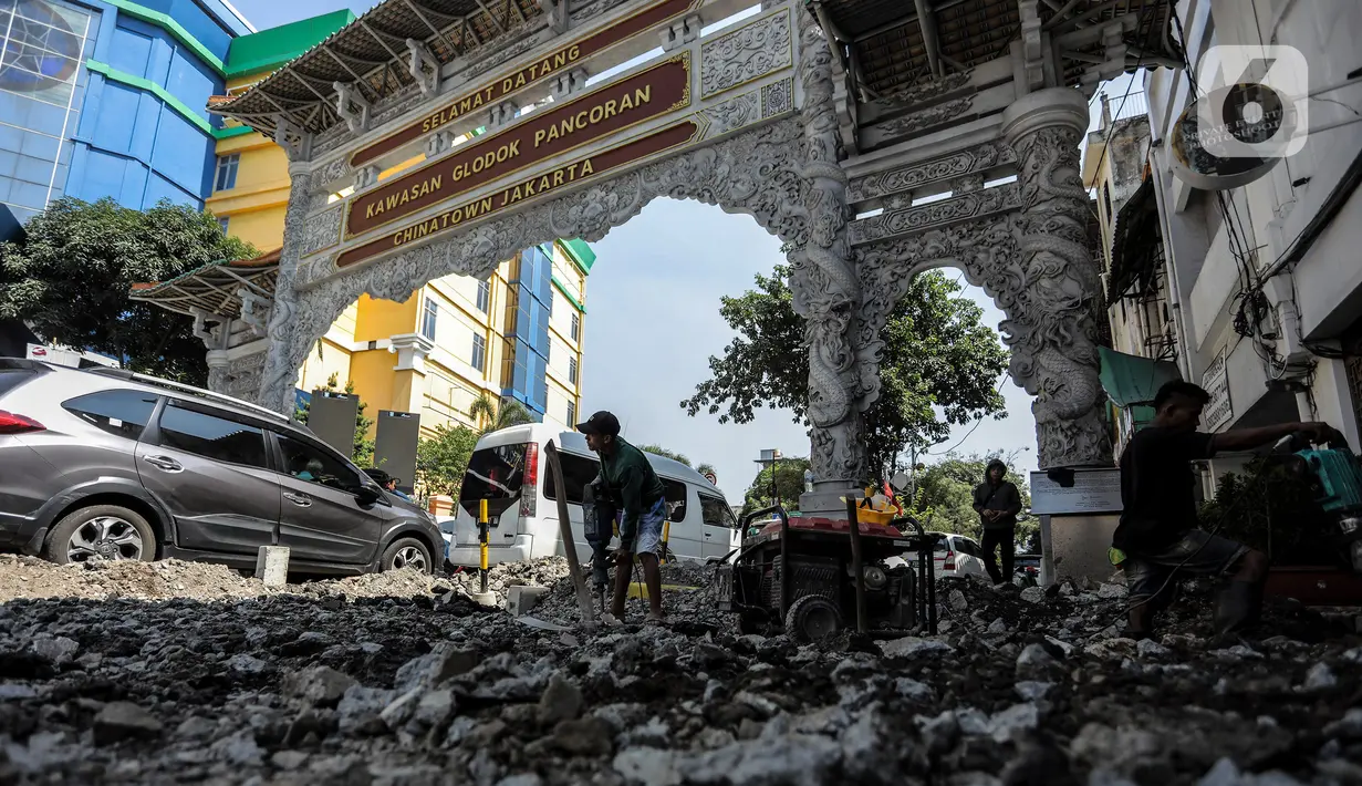 Pekerja saat mengerjakan perbaikan trotoar di Pasar Petak Sembilan, Glodok, Jakarta, Rabu (19/7/2023). (Liputan6.com/Johan Tallo)