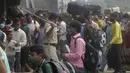 Polisi mencoba mengendalikan kerumunan yang tiba untuk naik kereta di Lokmanya Tilak Terminus di Mumbai, Minggu (11/4/2021). India melaporkan lonjakan infeksi COVID-19 yang menurut para ahli disebabkan oleh mengabaikan aturan jarak sosial serta mengenakan masker di ruang publik. (AP/Rafiq Maqbool)