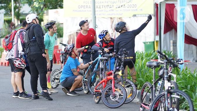 Sejumlah pesepeda berkumpul di kawasan Bundaran HI, Jakarta, Minggu (24/5/2020). Adanya PSBB serta Hari Raya Idul Fitri 1441 H dimanfaatkan sebagian warga untuk bersepeda di jalan protokol yang sepi dibanding hari biasa. (Liputan6.com/Immanuel Antonius)
