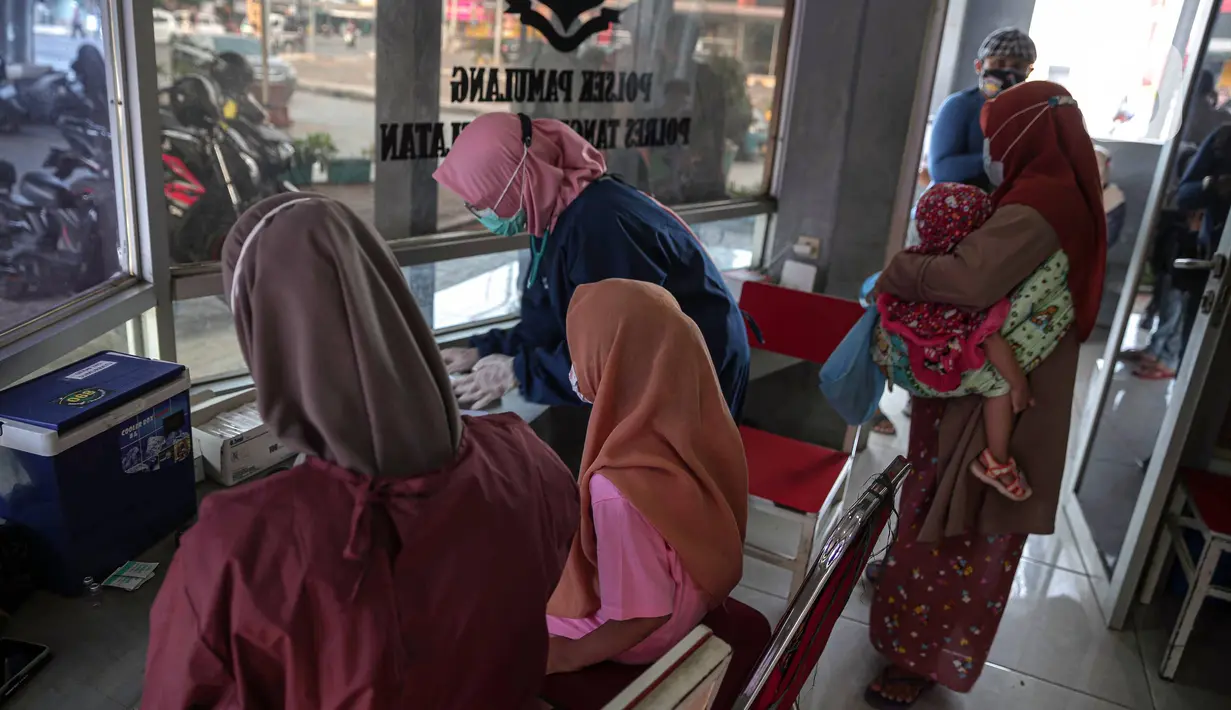 Petugas kesehatan mendata anak-anak saat vaksinasi COVID-19 Sinovac di Pospol Polsek Pamulang, Tangerang Selatan, Banten, Kamis (6/1/2022). Vaksinasi dilakukan untuk melindungi anak-anak dari keterpaparan COVID-19, khususnya varian Omicron, yang berkembang cukup cepat. (Liputan6.com/Faizal Fanani)
