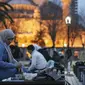 Orang-orang berbuka puasa dengan latar belakang Masjid Sultan Ahmed yang ikonik, lebih dikenal sebagai Masjid Biru, dihiasi dengan lampu dan slogan bertuliskan "Ramadhan adalah cinta," menandai bulan Ramadhan, di distrik bersejarah Sultan Ahmed di Istanbul (13/4/2021). (AP Photo/Emrah Gurel)