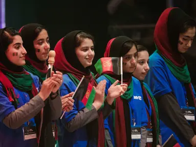 Tim perempuan dari Afghanistan mengikuti upacara pembukaan lomba robotik di Washington, AS, Minggu (16/7). Setelah sempat ditolak dua kali, akhirnya mereka memperoleh izin visa untuk terbang ke Negeri Paman Sam. (AP/Cliff Owen)