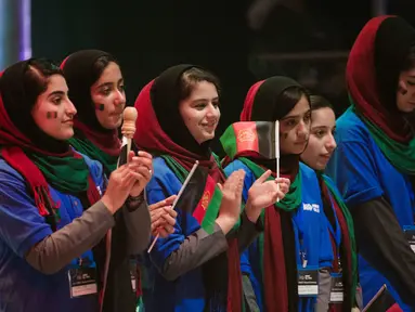Tim perempuan dari Afghanistan mengikuti upacara pembukaan lomba robotik di Washington, AS, Minggu (16/7). Setelah sempat ditolak dua kali, akhirnya mereka memperoleh izin visa untuk terbang ke Negeri Paman Sam. (AP/Cliff Owen)