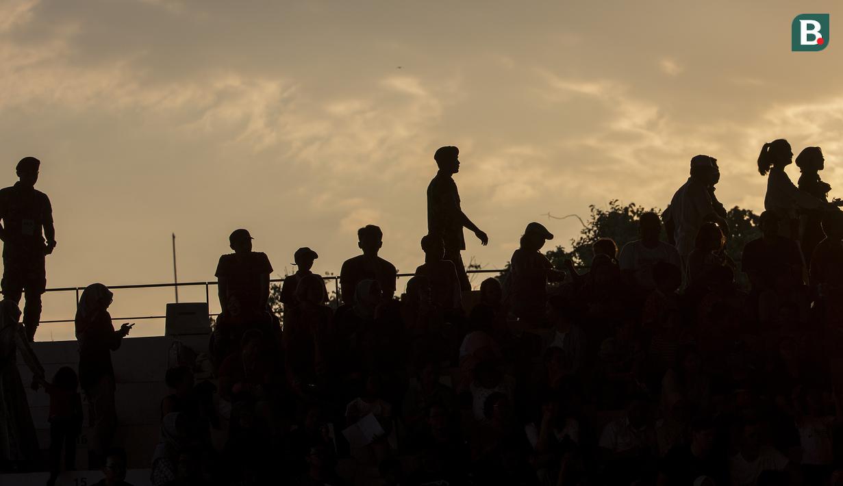 Siluet para penonton yang menyaksikan laga perempat final cabang polo air putra antara Kazakhstan vs Indonesia di Stadion Akuatik, GBK, Kamis (30/8/2018). (Bola.com/Peksi Cahyo)