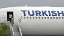 Petugas keamanan yang keluar pesawat Turkish Airlines melakukan percakapan dengan telepon selular usai pendaratan darurat di New Delhi, Selasa (7/7/2015). Pendaratan dilakukan karena teror bom secara tertulis di sebuah toilet pesawat. (REUTERS/Stringer)