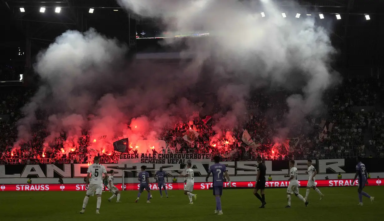 Pendukung Linzer ASK menyalakan suar saat laga Grup E Liga Europa 2023/2024 melawan Liverpool di Linz, Austria, Jumat (22/09/2023). Sempat tertinggal, Liverpool berhasil menang comeback atas Linzer ASK dengan skor 3-1. (AP Photo/Matthias Schrader)