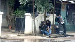 Polisi bersenjata api lengkap mengepung kantor Kelurahan Arjuna, Kecamatan Cicendo, Bandung, Senin (27/2). Baku tembak antara polisi dan seorang terduga teroris yang meledakkan benda di Taman Pandawa, terjadi di kantor lurah tersebut. (Timor Matahari/AFP)