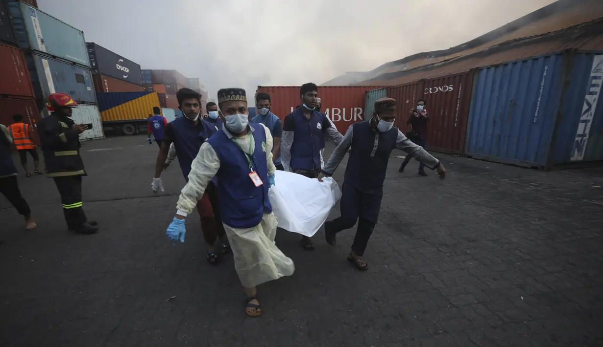 Orang-orang membawa jenazah korban kebakaran di BM Inland Container Depot, sebuah perusahaan patungan Belanda-Bangladesh, di Chittagong, 216 kilometer (134 mil) tenggara ibu kota, Dhaka, Minggu pagi (5/6/2022). Belum diketahui penyebab ledakan itu terjadi. Petugas menduga kebakaran berasal dari wadah hidrogen peroksida dan menyebar dengan cepat ke wadah lain. (AP Photo)