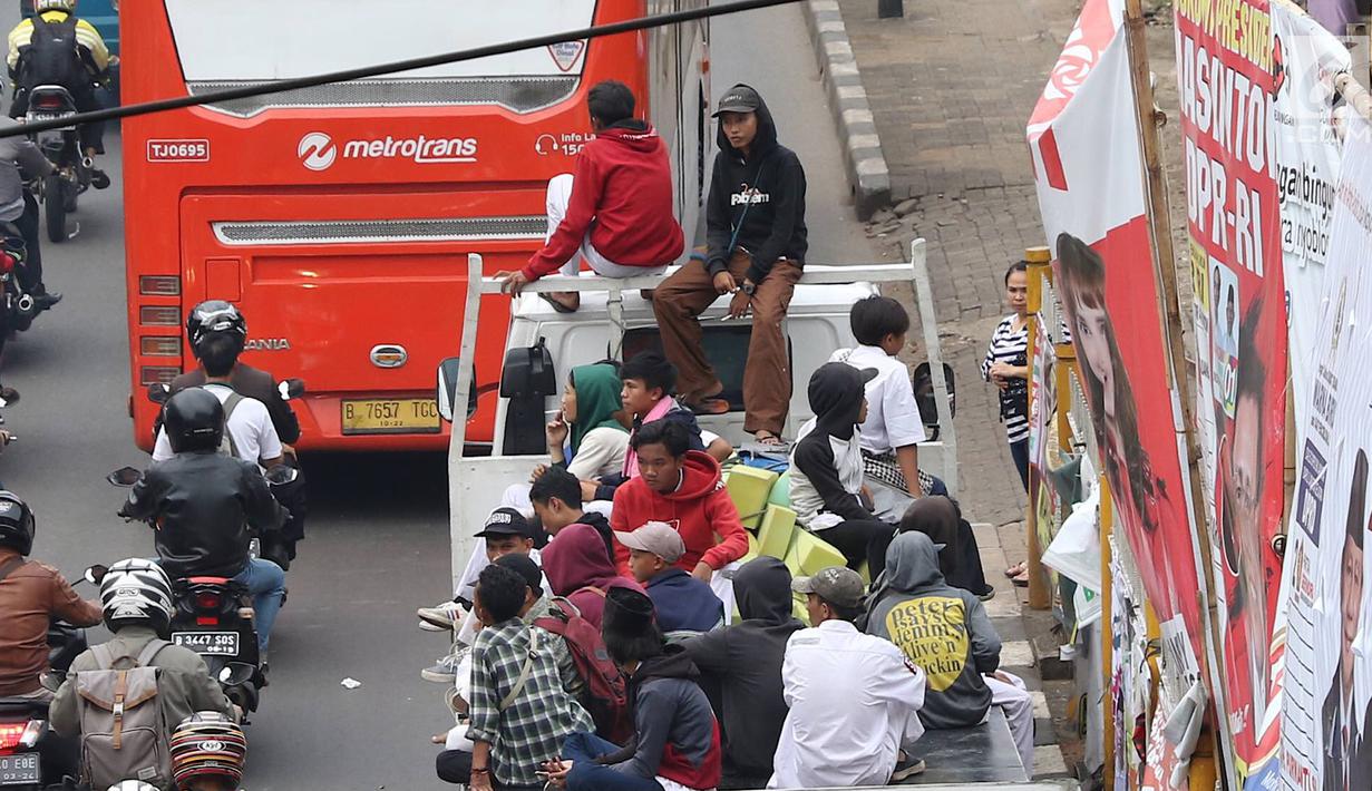 Pelajar menumpang truk terbuka yang melintas di kawasan Lenteng Agung, Jakarta, Senin (8/4). Perilaku buruk tersebut membahayakan keselamatan diri mereka dan pengguna jalan lain. (Liputan6.com/Immanuel Antonius)