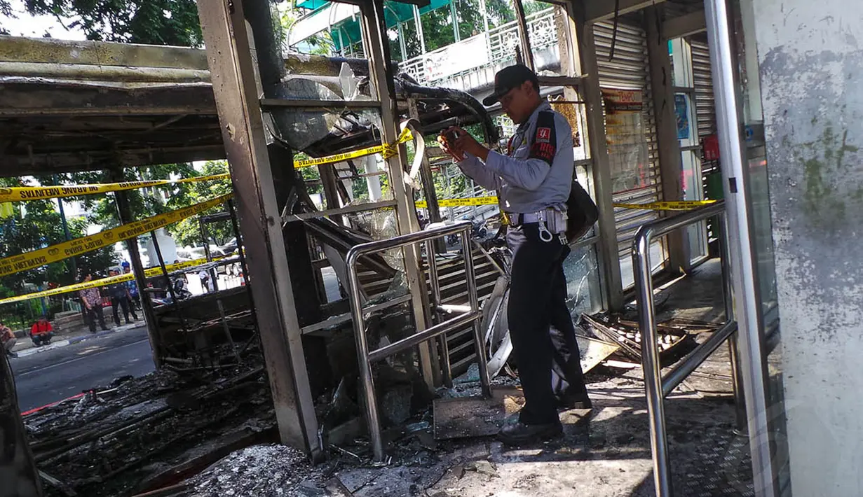 Seorang petugas terlihat mengambil foto dari kondisi halte yang sudah hangus, Jakarta, (28/8/14). (Liputan6.com/Faizal Fanani)