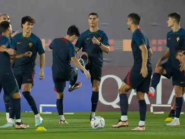 Cristiano Ronaldo (tengah) melakukan pemanasan dengan rekan satu timnya selama pelatihan resmi Portugal menjelang pertandingan sepak bola Piala Dunia grup H antara Portugal dan Ghana di tempat pelatihan Al Shahaniya SC, Al Shahaniya, Qatar, Rabu (23/11/2022). Dalam pertandingan nanti timnas Portugal akan berhadapan dengan Thomas Partey dan kawan-kawan. (AP Photo/Lee Jin-man)