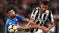 Penyerang Juventus, Mario Mandzukic (kanan) berebut bola dengan bek Napoli, Elseid Hysaj saat bertanding pada lanjutan Liga Serie A Italia di Stadion Allianz di Turin (22/4). Juventus takluk atas Napoli 1-0. (AFP Photo/Marco Bertorello)