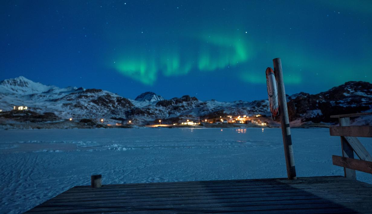 Pemandangan fenomena alam Aurora Borealis atau Northern Lights di Kepulauan Lofoten, Bostad, lingkaran Arktik, Norwegia, Sabtu (3/3). Cahaya Aurora biasa terlihat di sekitar daerah Kutub Utara dan Selatan. (Olivier MORIN/AFP)