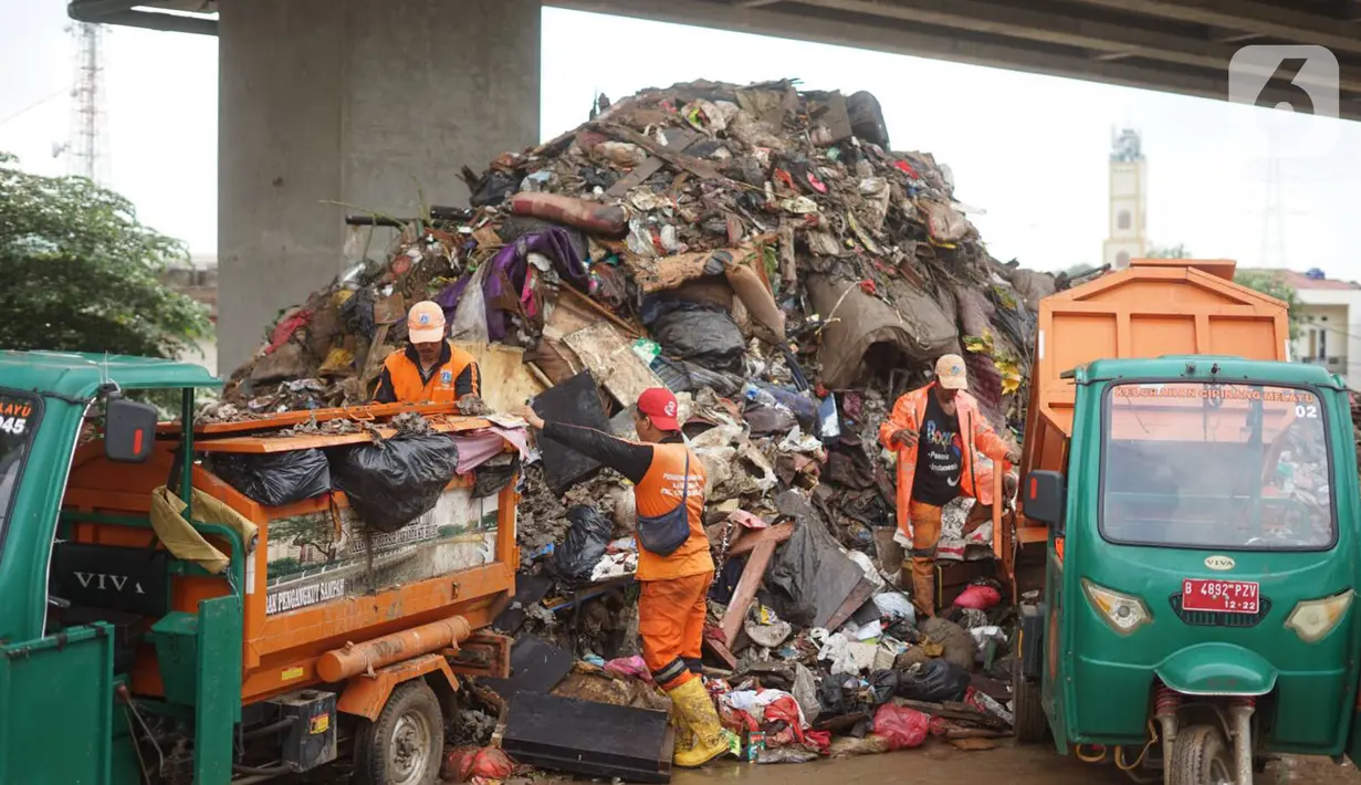 Petugas mengangkut sampah sisa banjir yang menumpuk di kawasan Cipinang Melayu, Jakarta, Senin (6/1/2020). Banjir yang menggenangi Jakarta dan sekitarnya sejak 1 Januari 2020 lalu menyisakan tumpukan sampah di sejumlah titik. (Liputan6.com/Immanuel Antonius)