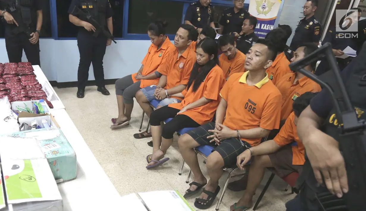 Tersangka kasus narkoba diperlihatkan saat rilis di Gedung Kantor Pos Pasar Baru, Jakarta, Senin (10/9). 30ribu butir happy five juga diselundupkan melalui barang kiriman pos. (Liputan6.com/Immanuel Antonius)