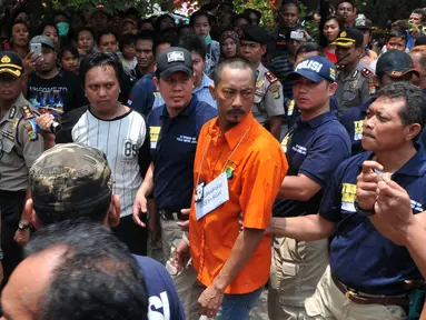 Tersangka pembunuhan ibu dan anak, Dayu Pri Ambarita dan Yuel Imanuel mengikuti rekonstruksi pembunuhan di Perumahan Aneka Elok, Cakung, Jakarta, Selasa (27/10). Mengenakan baju tahanan, Heri datang dengan pengawalan ketat. (Liputan6.com/Andrian M Tunay)