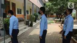 Pelajar SMK Telekomunikasi Telesandi mencoba alat pengukur suhu tubuh bernama tels meter di Tambun, Kabupaten Bekasi, Selasa (5/10/2021). Alat yang dilengkapi dengan kamera pendeteksi masker dan cairan pembersih tangan ini dijual dengan harga Rp 1,5 juta - Rp 2 juta. (Liputan6.com/Hermann Zakharia)