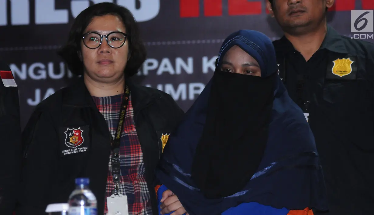 Tersangka kasus penipuan calon jemaah umroh, Anniesa Hasibuan mengenakan cadar saat diperlihatkan polisi di Bareskrim Mabes Polri, Jakarta, Selasa (22/8). Hingga kini, polisi telah menetapkan tiga tersangka kasus tersebut (Liputan6.com/Helmi Fithriansyah)