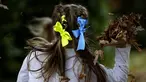 Anak-anak dengan pita warna nasional Ukraina di rambut mereka bermain di perayaan hari Kemerdekaan Ukraina di sebuah perayaan di Chichester, Inggris selatan, Sabtu, 27 Agustus 2022. Chichester dinobatkan sebagai daerah paling dermawan di negara itu untuk menampung pengungsi Ukraina. (AP Photo/Frank Augstein)