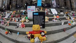 Boneka mainan diletakkan di halaman gedung Kongres Kolombia untuk memprotes kekerasan seksual terhadap anak-anak di Bogota, Selasa (20/11). Protes bertujuan untuk meningkatkan kesadaran tentang tanggung jawab perlindungan anak-anak. (DANIEL MUNOZ/AFP)