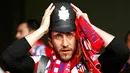 Salah satu fans Atletico Madrid terlihat memakai replika helm polisi tradisional Inggris saat menyaksikan laga semifinal kedua Liga Champions, Stamford Bridge, London (1/5/02014). (REUTERS/Eddie Keogh)
