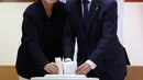 Calon presiden Korsel dari Partai Demokrat Moon Jae-in bersama istrinya memasukkan kertas suara di sebuah TPS di Seoul, Selasa (9/5). Hari ini, warga Korsel mulai memilih presiden baru setelah pemakzulan Park Geun-hye. (Jeon Heon-kyun/Pool Photo via AP)