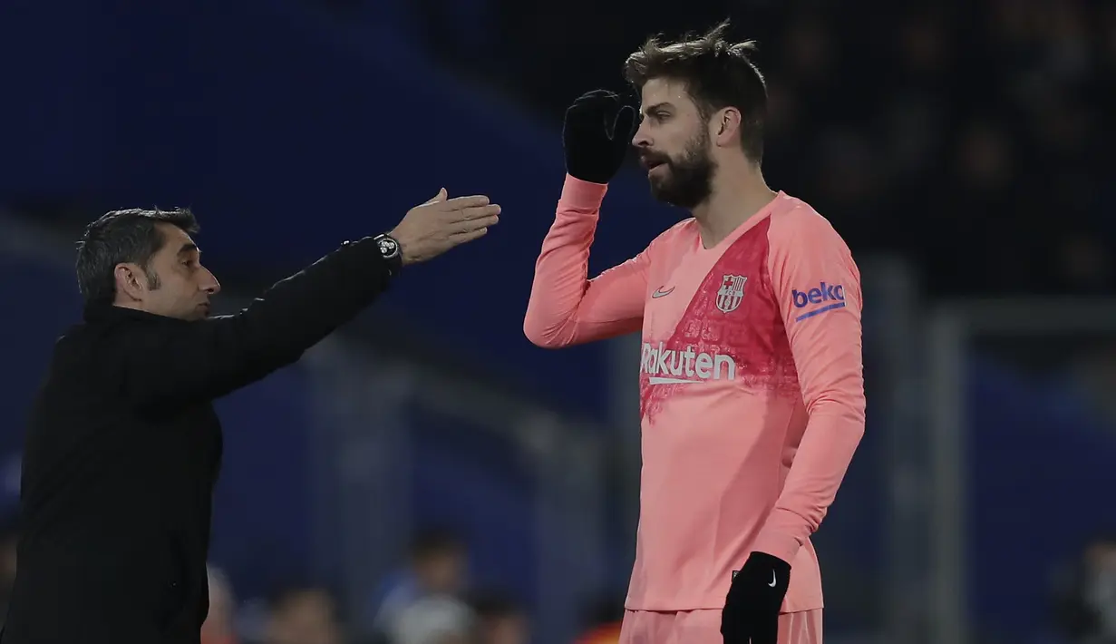 Pelatih Barcelona, Ernesto Valverde, memberi arahan kepada Gerard Pique, saat melawan Getafe pada laga La Liga di Stadion Alfonso Perez, Minggu (6/1). Barcelona menang 2-1 atas Getafe. (AP/Manu Fernandez)