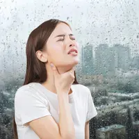 Seorang perempuan sedang kesakitan dan memegang tenggorokannya dengan latar cuaca Jakarta (Foto Dok: Hasta Communications).