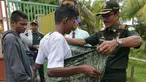 Polisi Syariat Islam memakaikan kain sarung pada warga bercelana pendek saat razia penertiban hukum syariat islam di Banda Aceh, Aceh, Selasa (19/9). Razia digelar sebagai implementasi Qanun Aceh No 11 Tahun 2002. (CHAIDEER MAHYUDDIN/AFP)